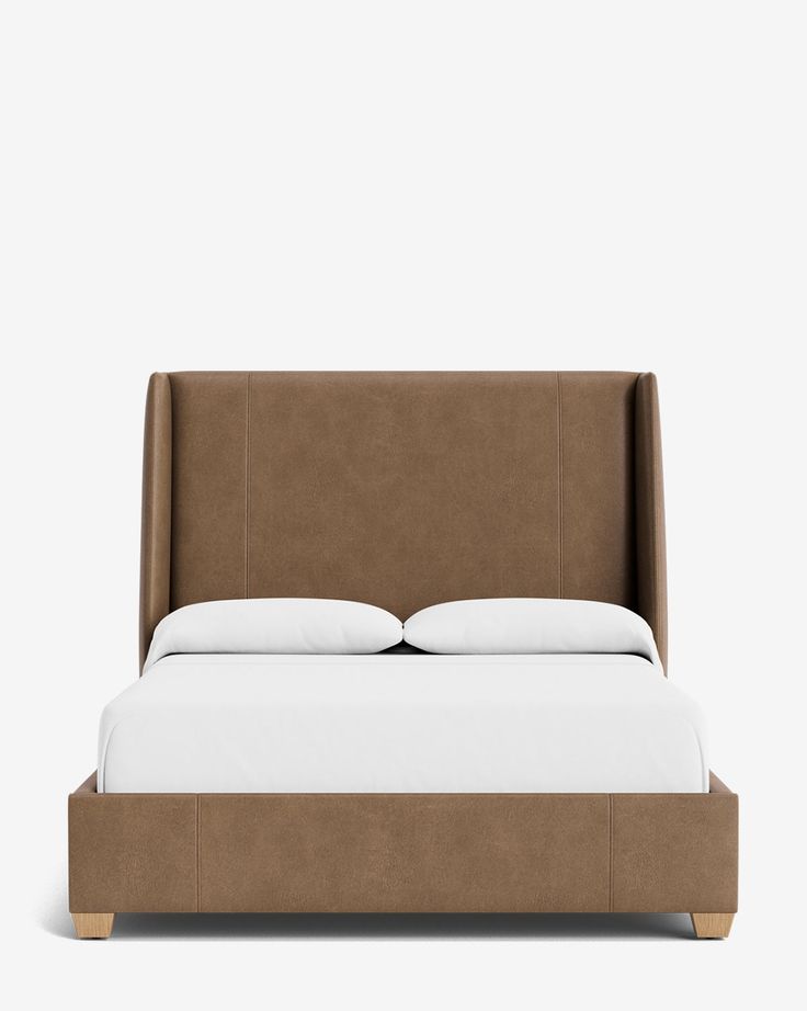 an upholstered bed with white pillows and brown headboard, in front of a gray background