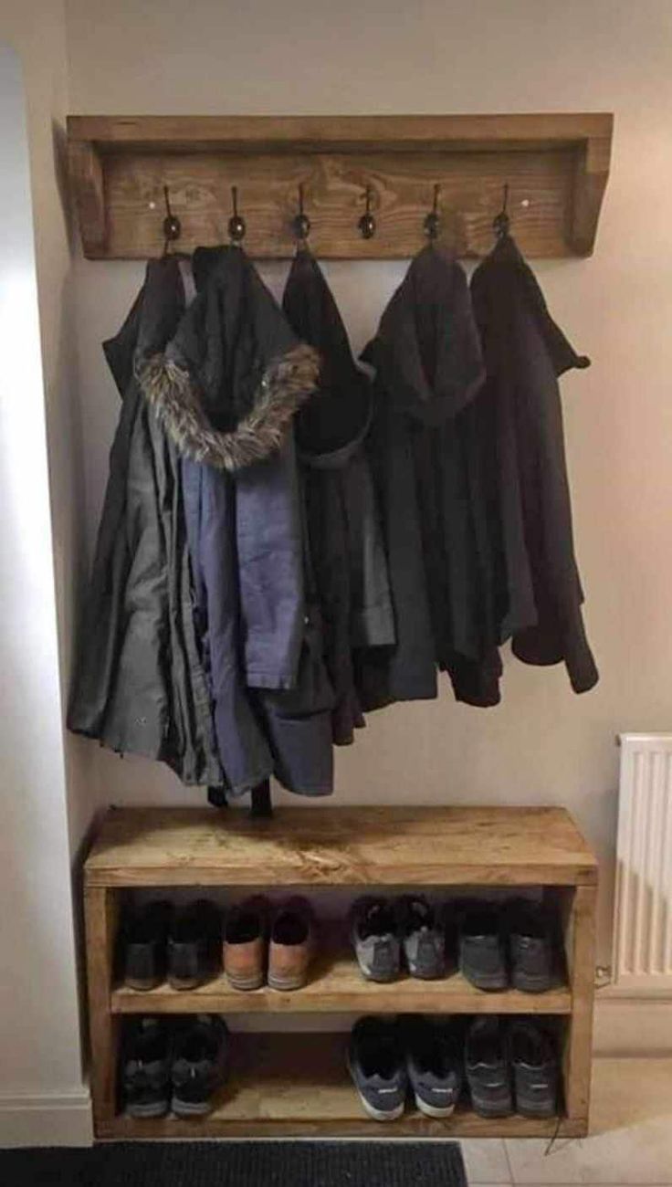 a coat rack with shoes and coats hanging on it