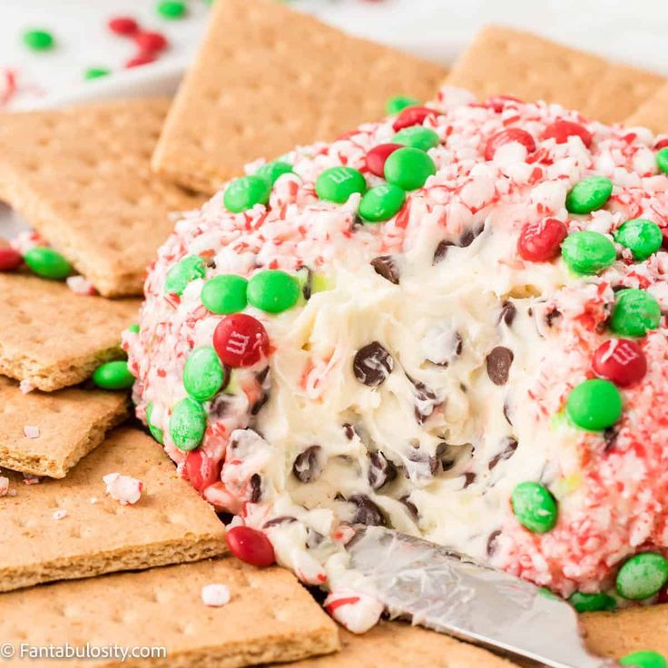 a large cracker covered in candy and sprinkles with a serving knife