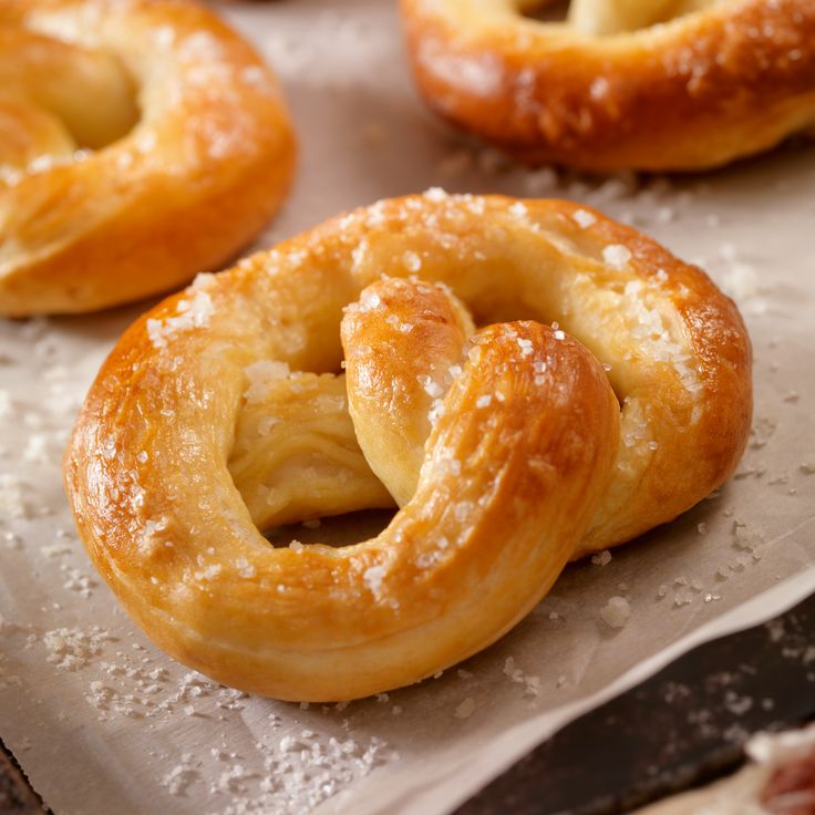 some very tasty looking doughnuts sitting on a piece of waxed paper