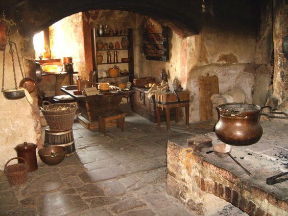 an old fashioned kitchen with pots and pans on the stove top, in a stone walled room