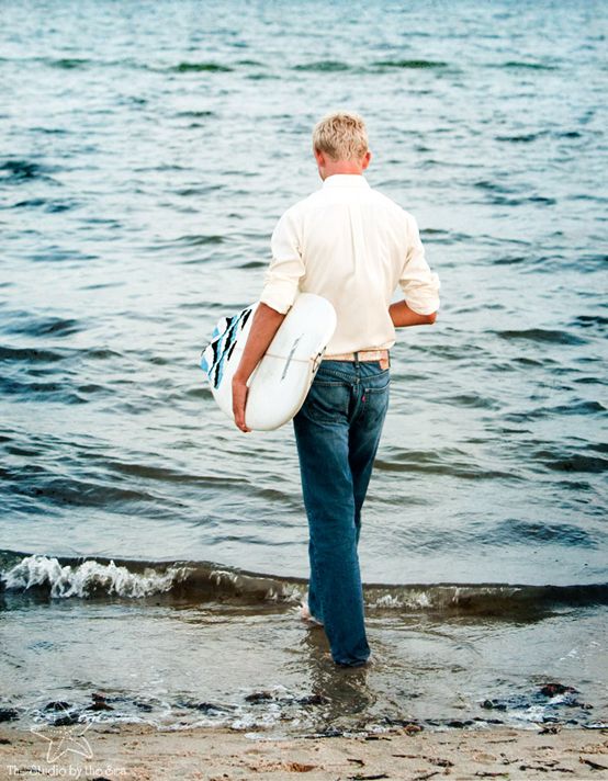 a man holding a surfboard walking into the water