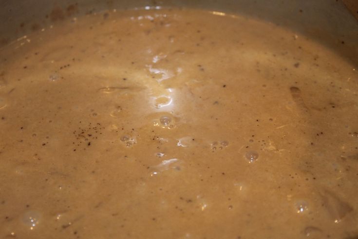 a pot filled with brown liquid sitting on top of a stove