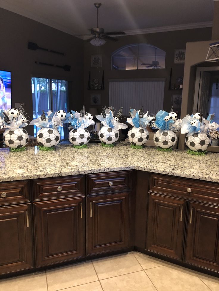 a kitchen counter topped with lots of soccer balls