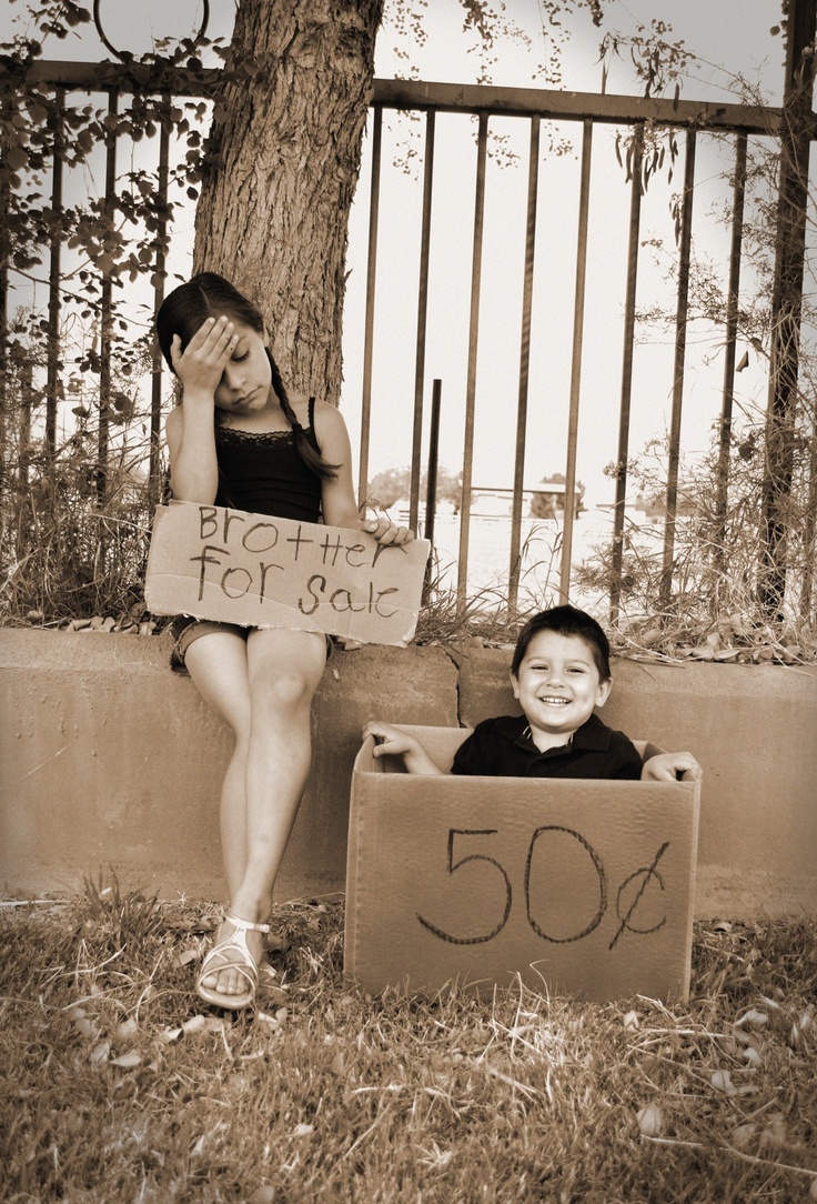 two young children sitting on the ground in front of a tree with a sign that says 50 %