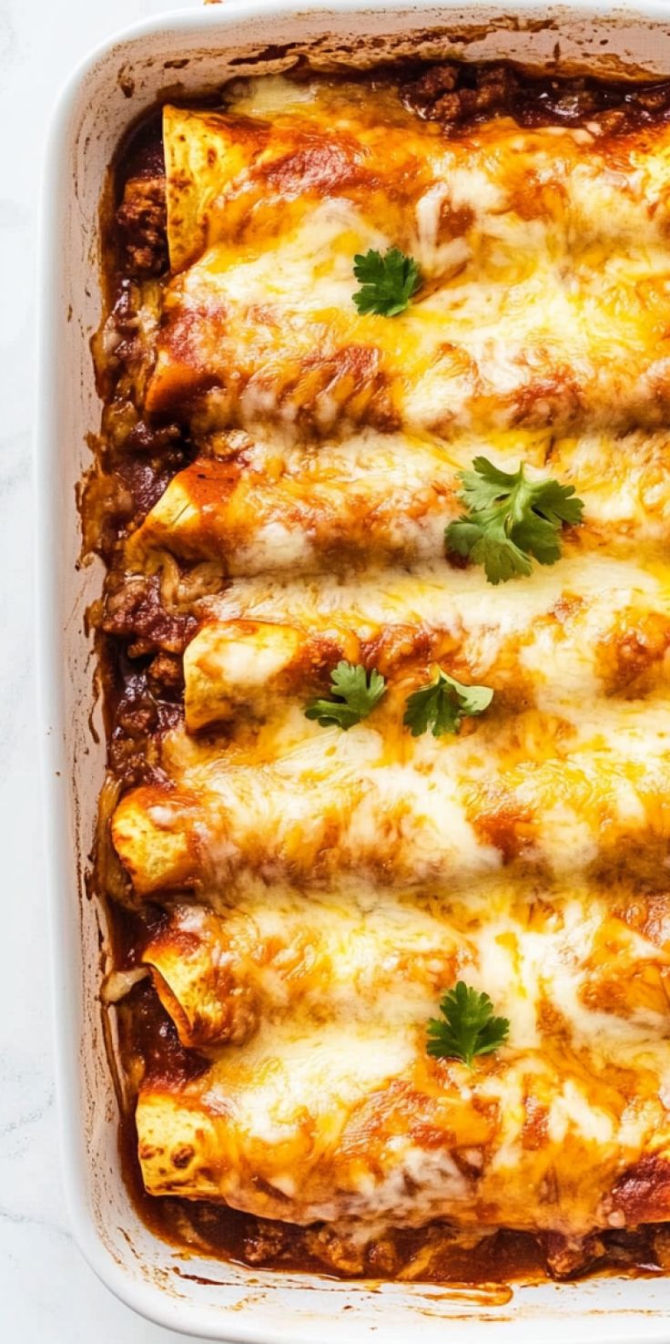 an enchilada casserole with meat and cheese in a white dish