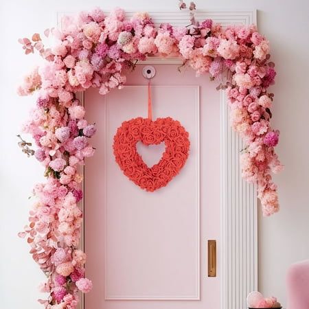 a pink door with a heart shaped wreath hanging from it's side next to a pink chair