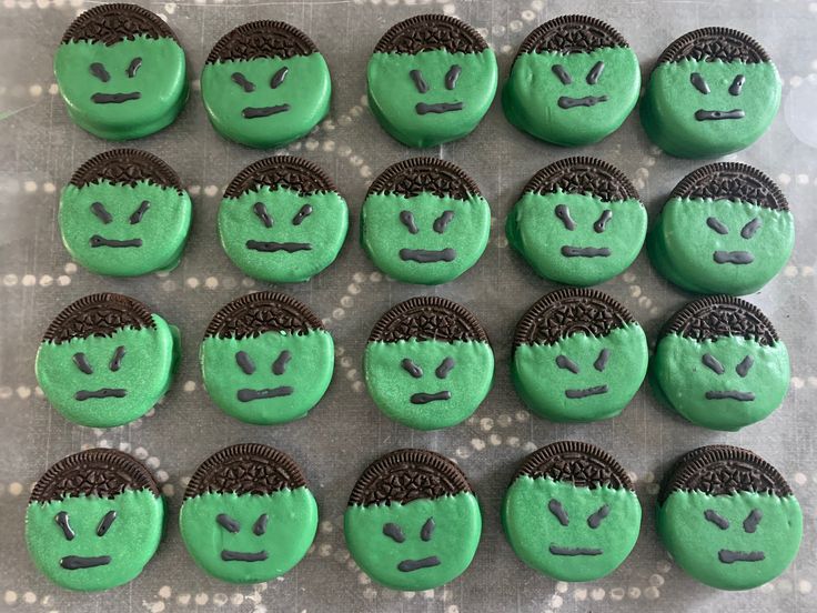 there are many green and black cookies with faces on them