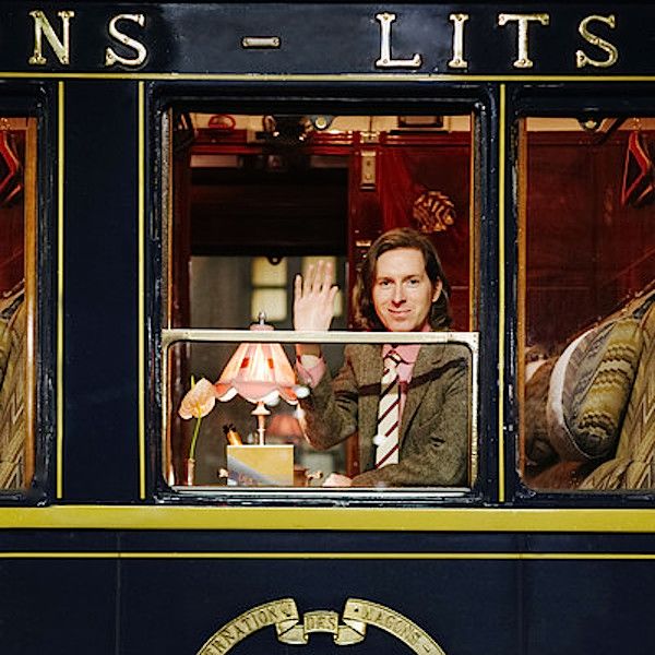 a man waving out the window of a train