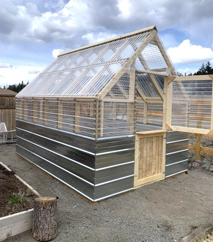 a small greenhouse built into the side of a house