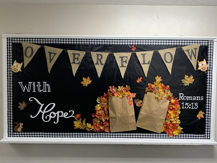 a bulletin board with paper bags and fall leaves on it that says overflow with hope