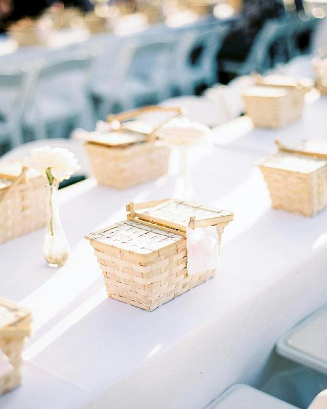 the table is set up with baskets and flowers for guests to sit down in their seats