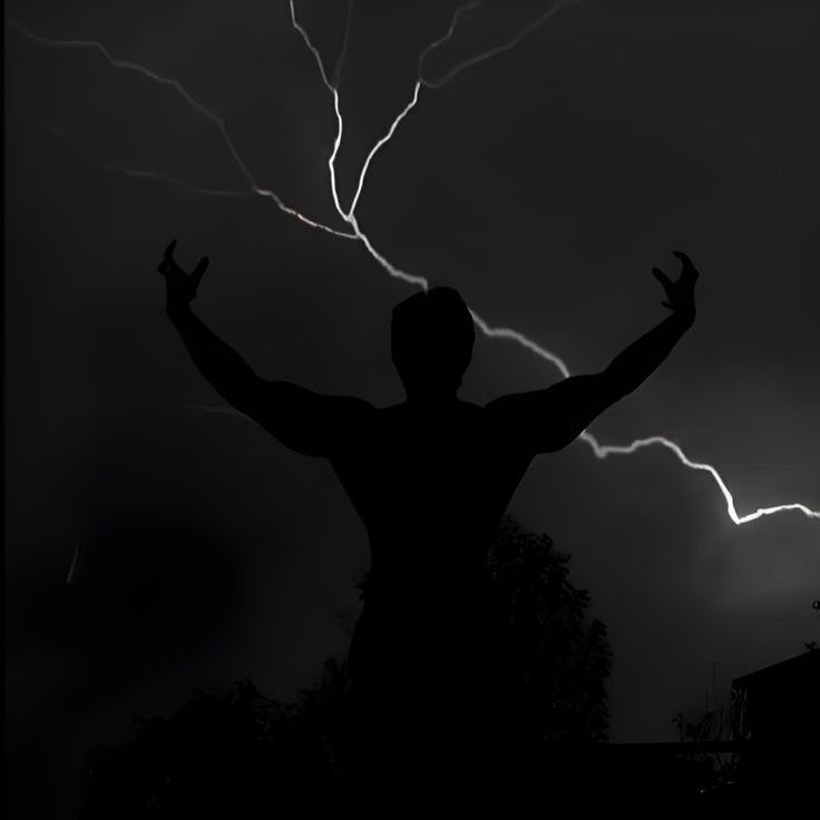 a man standing in the dark with his arms wide open while lightning strikes behind him