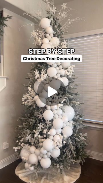 a christmas tree decorated with white balls and snowflakes is featured in this video