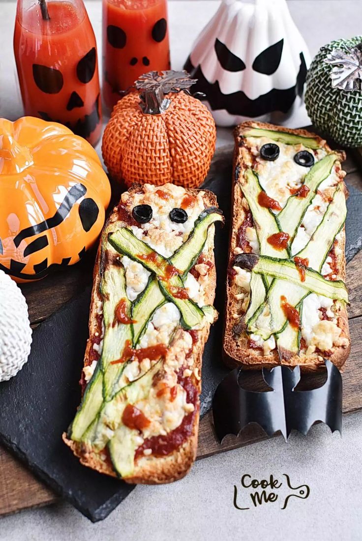 several slices of pizza sitting on top of a cutting board next to pumpkins and candles