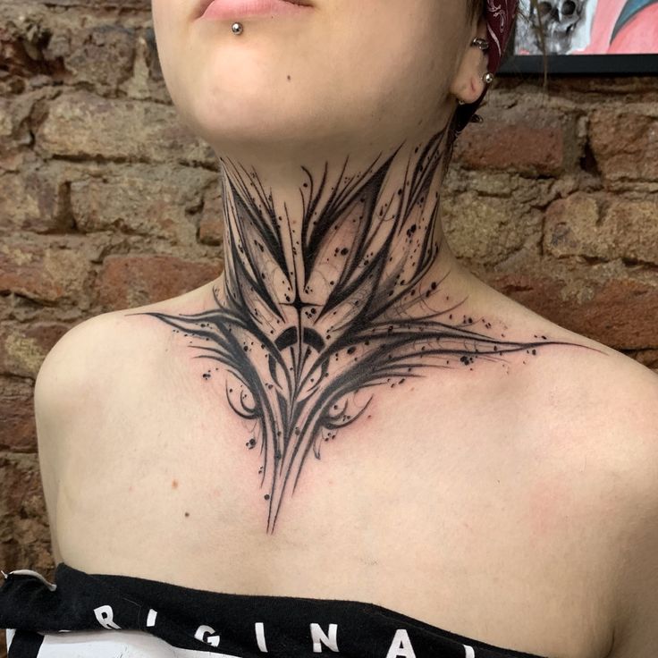 a woman with a black and white tattoo on her neck