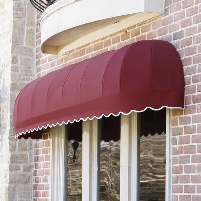 a brown awning on the side of a brick building next to a white door