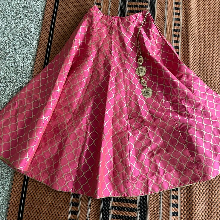 Pink Silk Skirt With Golden Printed Design. Skirt Comes With Attached Ornaments And Cancan. Minimum 8 Meteres Of Flare. It Is One Size Fits All. Can Be Styled With White Basic Or Satin Shirt Or It Can Be Also Styled With Crop Tops Or Blouses (Yellow, Blue, Gold, Or White Colored Blouses). Price Is Negotiable Elegant Skirt With Traditional Drape For Reception, Elegant Reception Skirt With Traditional Drape, Elegant Traditional Drape Skirt For Reception, Elegant Skirt Set For Festivals, Elegant Festive Lehenga With Flowy Skirt, Elegant Party Lehenga With Long Skirt, Elegant Skirt Set With Zari Work In Traditional Drape, Pink Silk Full Skirt, Elegant Skirt Set With Zari Work For Festive Occasions