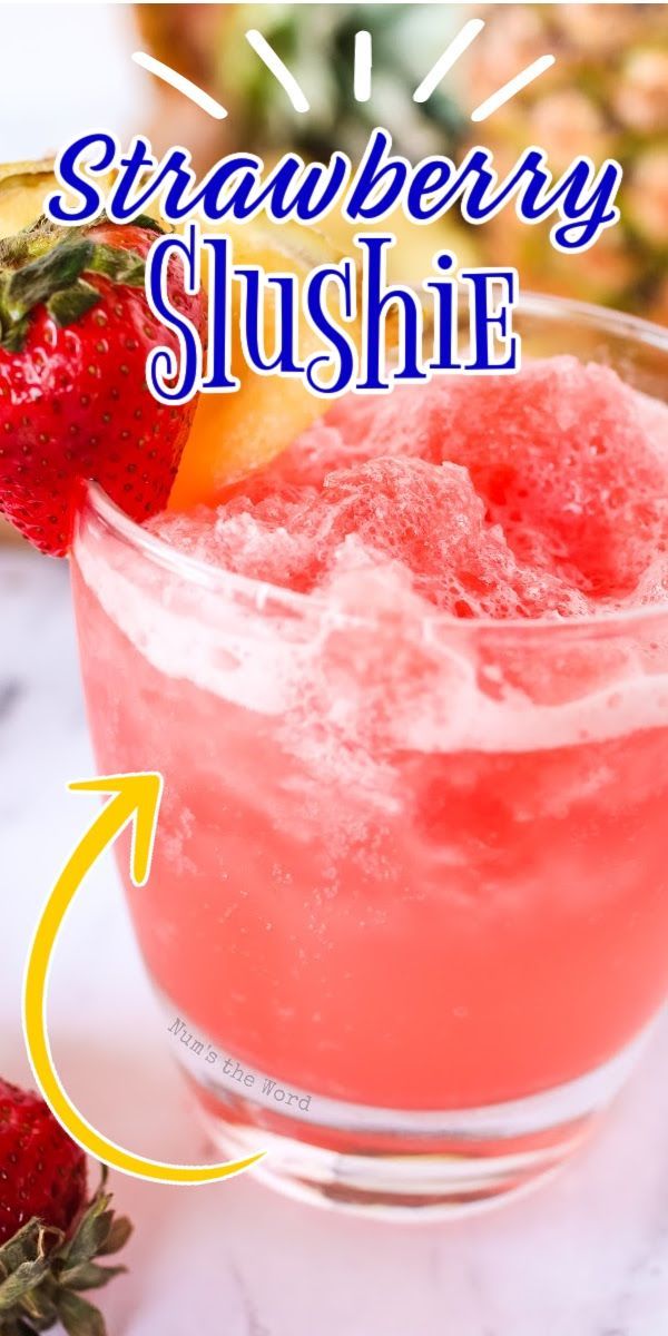 a strawberry slushie in a glass with ice and strawberries on the side