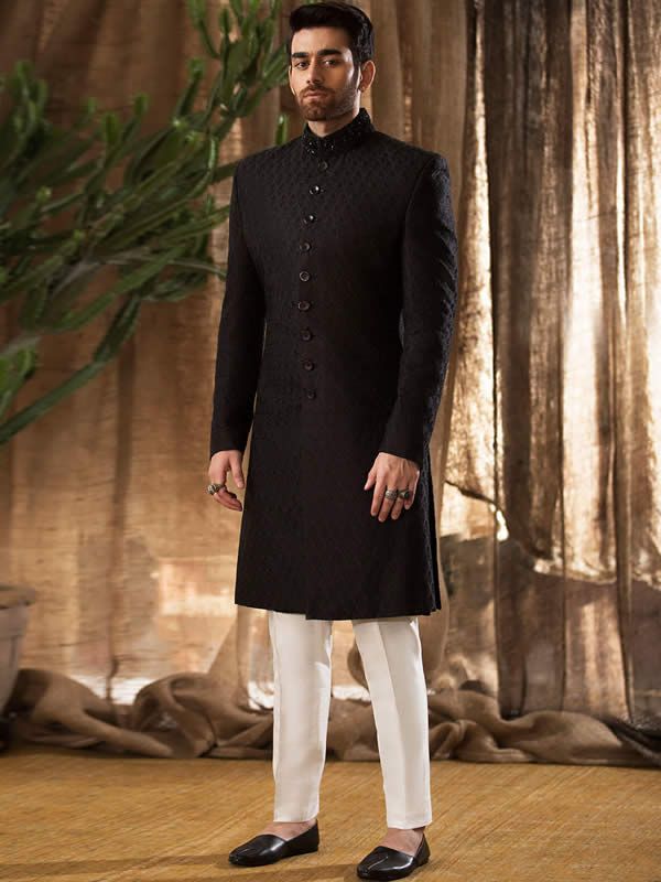 Sherwani:Color: BlackFabric: Raw SilkSherwani features rich quality embellishments accent on collarFanciful front button closure  Inner:Comes with off-white kurta and pajama  Additional Accessories:Jodhpuri/Saleem Shahi Shoes: US$30 (Made with sherwani material & embroidery)  Note: Price of all sherwani suits includes only 3 pieces i.e. sherwani, kurta and pajama (or whatever bottom is mentioned in product description). Extra charges will apply for any additional accessories like shawl, turb Traditional Fit Long Sleeve Sherwani With Chikankari Embroidery, Designer Traditional Wear With Chikankari Embroidery For Formal Occasions, Designer Chikankari Embroidery Traditional Wear For Formal Occasions, Designer Chikankari Embroidery Formal Traditional Wear, Bandhgala With Chikankari Embroidery For Eid, Festive Long Sleeve Traditional Fit Sherwani, Designer Formal Traditional Wear With Chikankari Embroidery, Traditional Fit Long Sleeve Bandhgala For Diwali, Eid Bandhgala With Chikankari Embroidery And Stand Collar