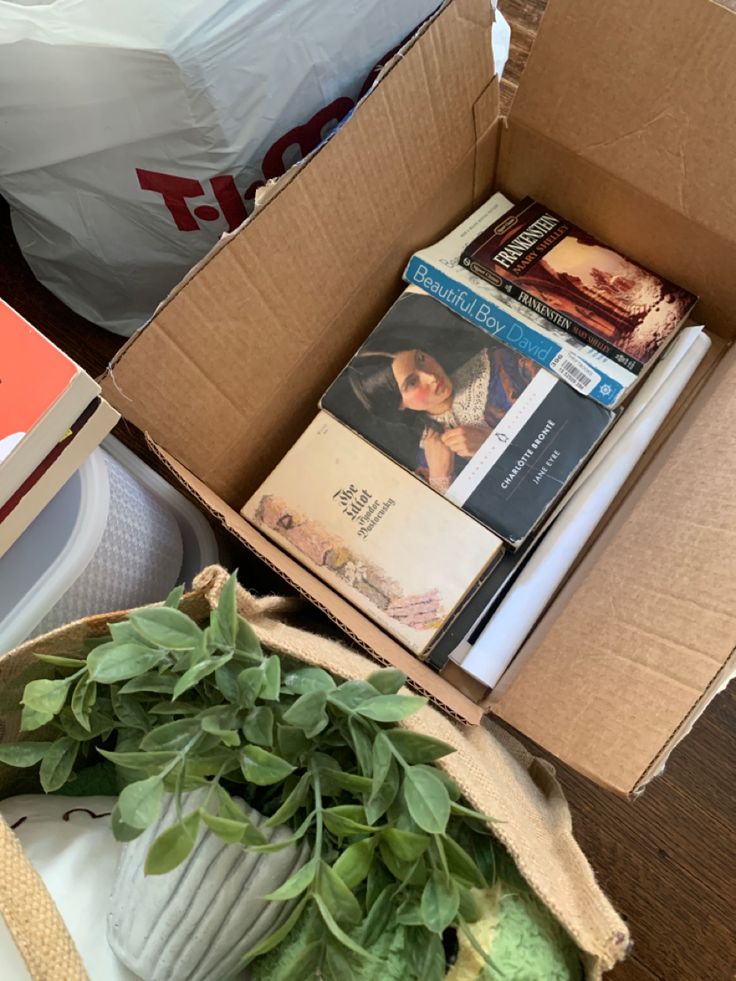 a box filled with books and plants on top of a table