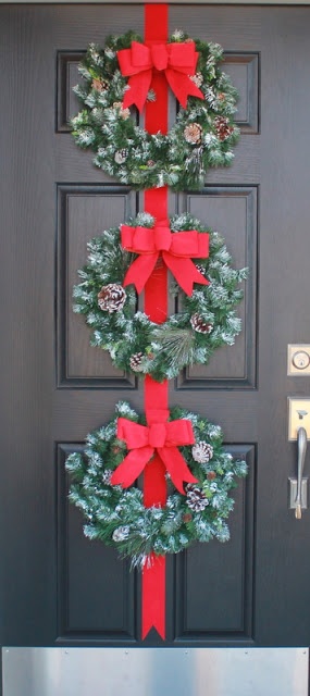 a door decorated with christmas wreaths and bows