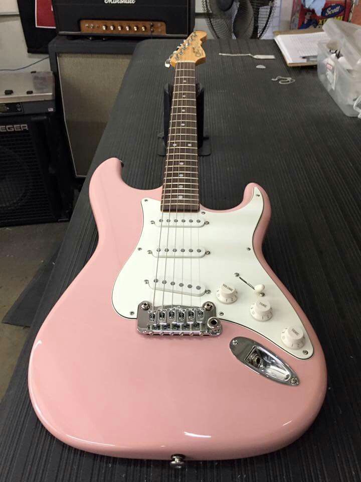 a pink guitar sitting on top of a table