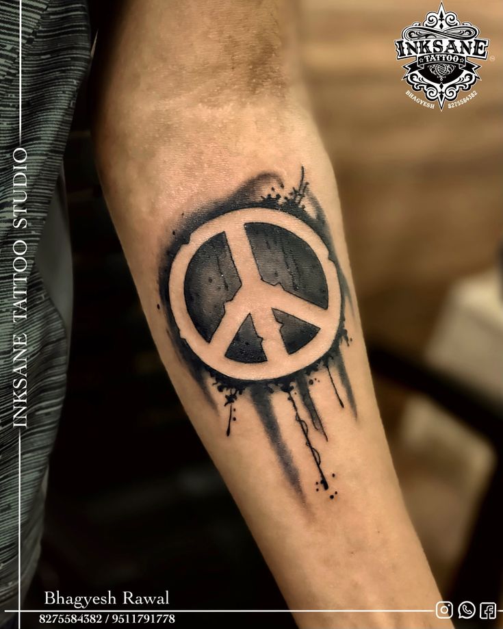 a man's arm with a peace sign tattoo on it