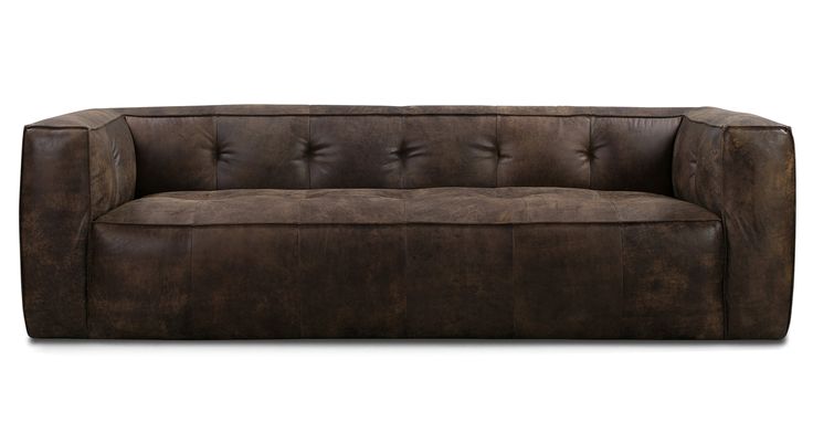 a brown leather couch sitting on top of a white floor