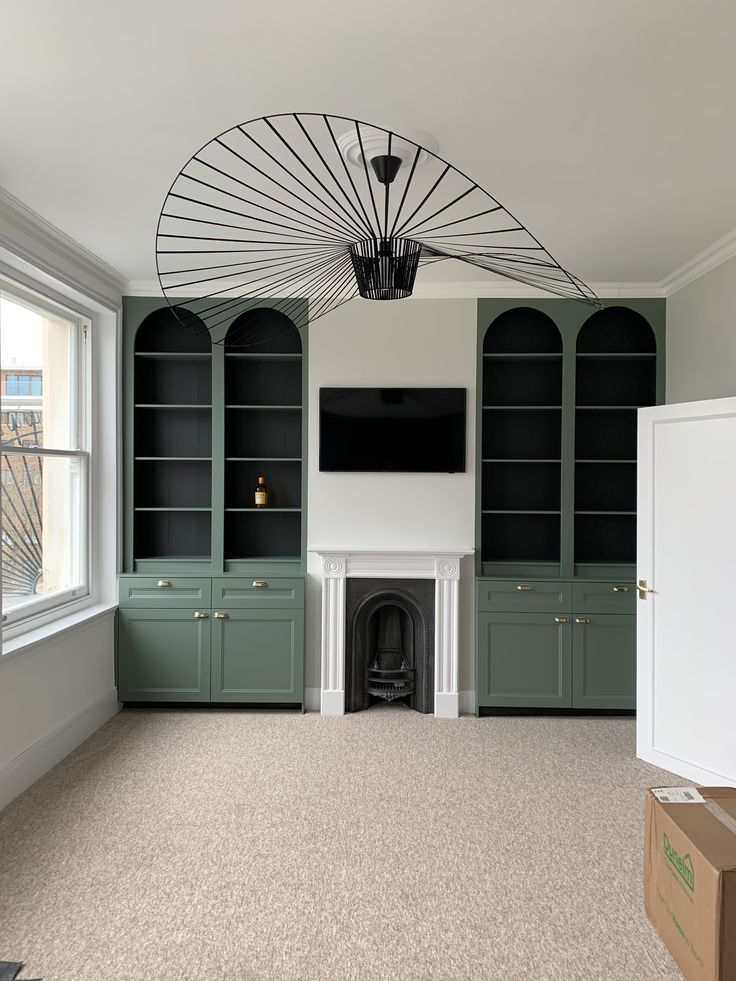 an empty room with built in bookcases and a fireplace