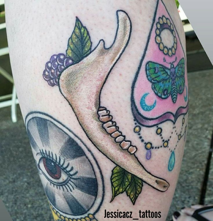 a close up of a person's leg with tattoos on it and an eye