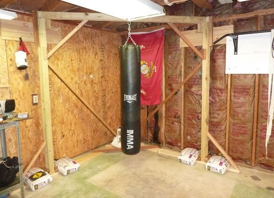 a boxing bag hanging from the ceiling in a room with wooden walls and exposed rafters