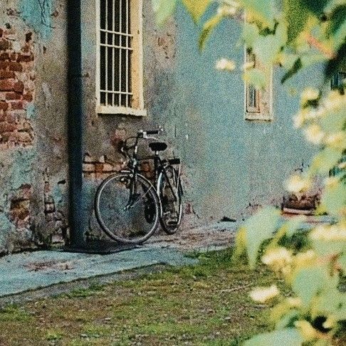 there is a bike parked in front of the door to an old building that has been painted blue