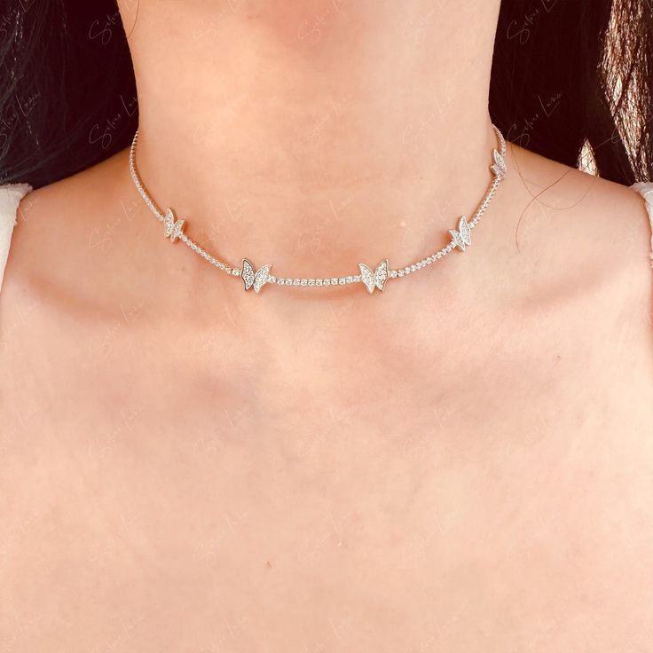 Enhance your fine jewelry collection with this exquisite cubic zirconia butterfly choker necklace. The intricate butterfly design, set on a solid 925 sterling silver chain, adds a touch of elegance to any outfit. Versatile enough to layer with longer necklaces, this piece is a must-have for any jewelry lover. Whether worn every day or for a special occasion, this necklace will make you feel like a beautiful bride. Materials: 925 sterling silver, cubic zirconiaFinish: platinum plateChoker length: Fine Jewelry Cubic Zirconia Necklace With Butterfly Charm, Fine Jewelry With Cubic Zirconia Butterfly Charm, Delicate Butterfly Jewelry With Cubic Zirconia, White Gold Butterfly Necklace With Cubic Zirconia, Delicate Butterfly-shaped Jewelry With Cubic Zirconia, Delicate Butterfly Cubic Zirconia Jewelry, Delicate Butterfly-shaped Cubic Zirconia Jewelry, Delicate Jewelry With Cubic Zirconia Butterfly Charm, Elegant Silver Butterfly Necklace In Cubic Zirconia