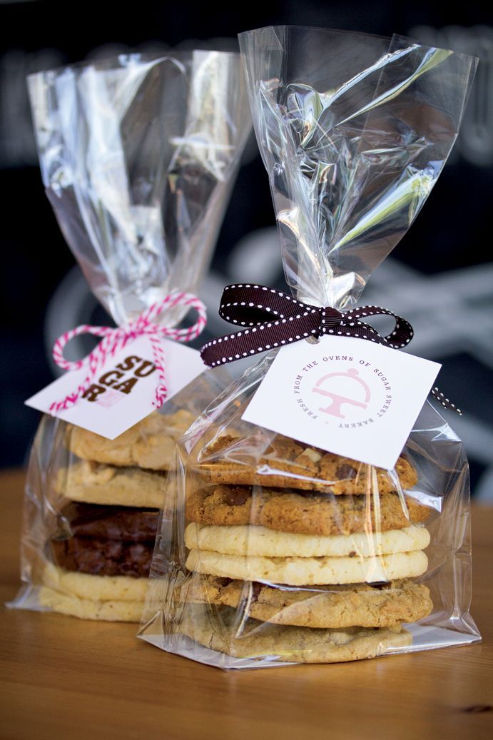 cookies wrapped in cellophane and tied with ribbon on top of a wooden table