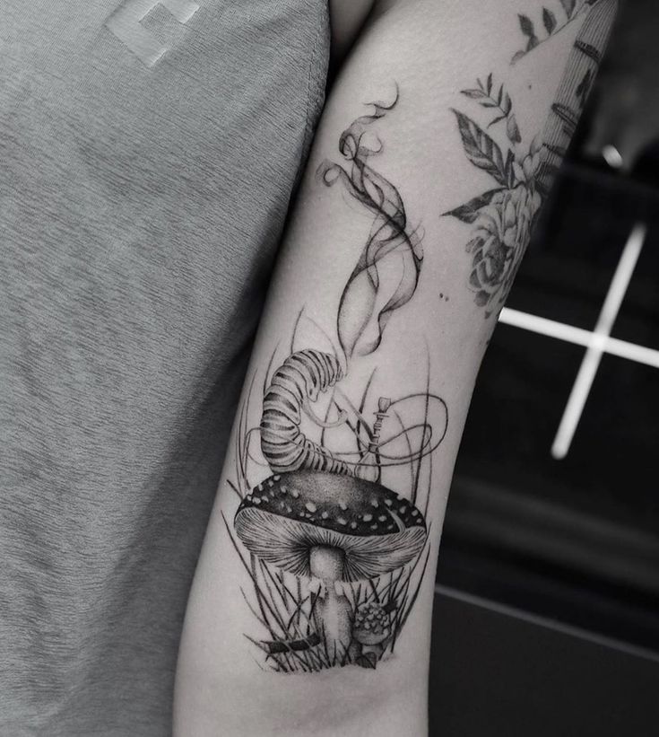 a black and white photo of a mushroom tattoo on the arm