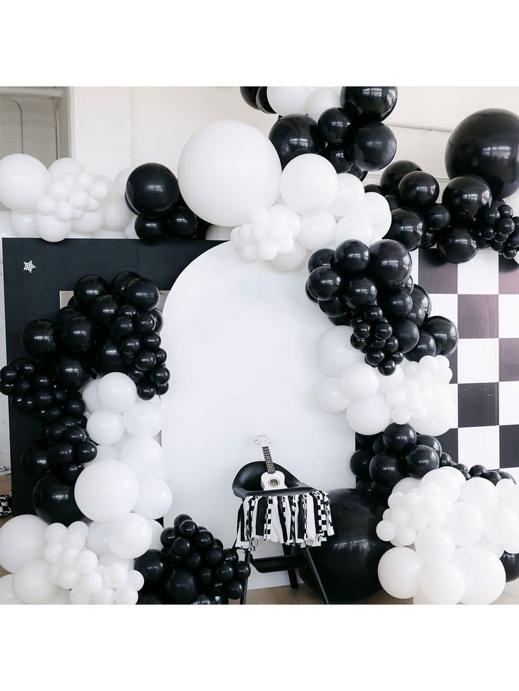 black and white balloon arch with checkerboard backdrop