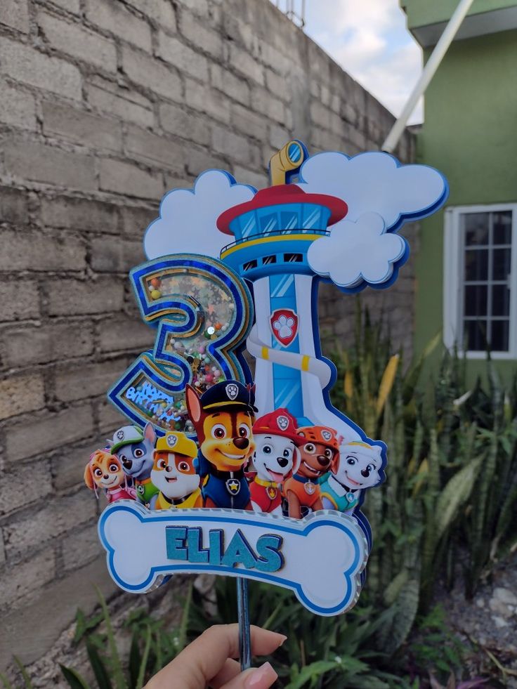 a hand holding up a sign with cartoon characters on it