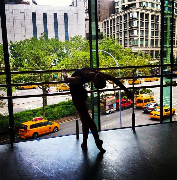 a woman standing in front of a window next to taxi cabs