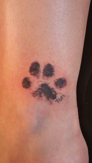 a dog paw tattoo on the ankle