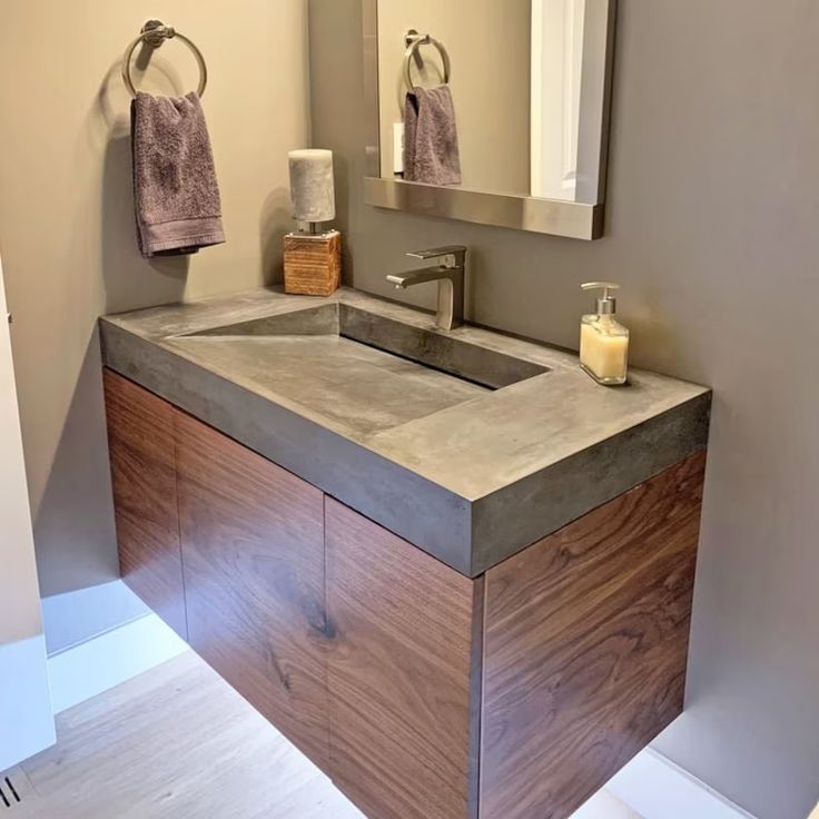 a bathroom with a sink, mirror and towel rack