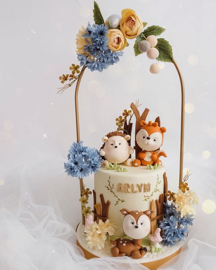 a three tiered cake decorated with animals and flowers