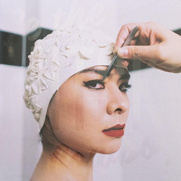 a woman is getting her hair cut by a man in a white turban