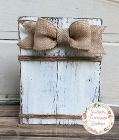 a wooden box with burlocks and a bow on the top is sitting in front of a door