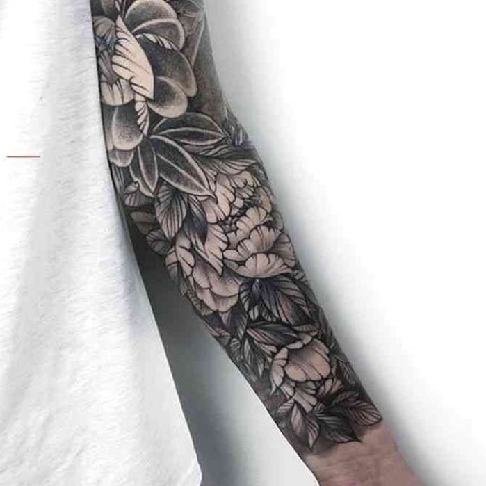 a man's arm with flowers and leaves tattooed on the left side of his arm