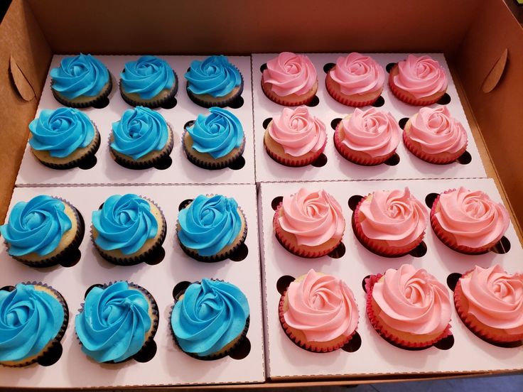 a box filled with blue and pink cupcakes