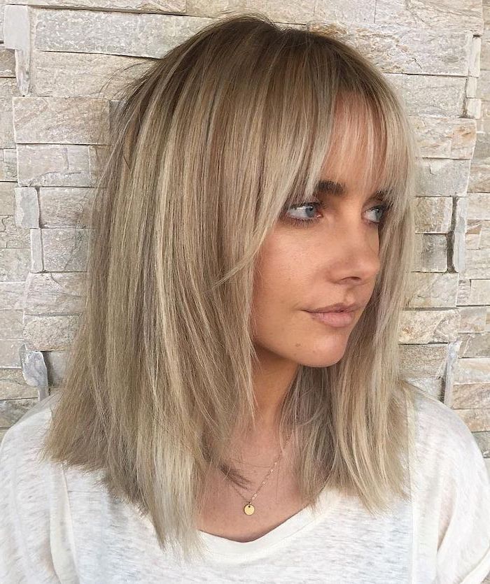 woman-with-blonde-hair-with-bangs-wearing-white-t-shirt-medium-length-layered-hair-brick-wall Wispy Bangs Lob, Blonde Lob With Bangs, Hairstyles With Fringe, Lob With Bangs, Shape Face, Blonde Lob, Medium Layered Hair, Smink Inspiration, Wispy Bangs