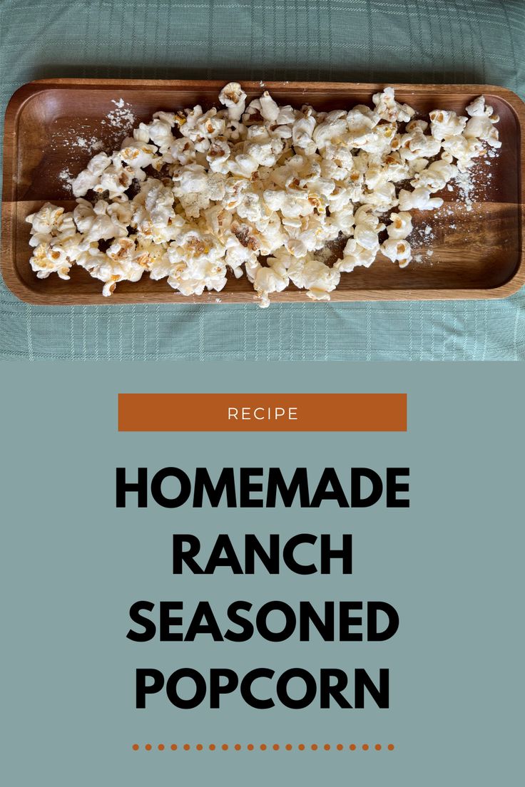 the recipe for homemade ranch seasoned popcorn is shown on a wooden tray with blue cloth