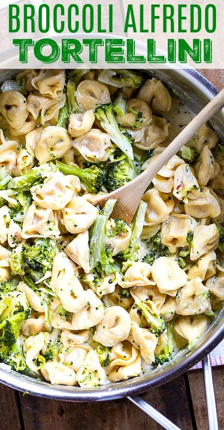 broccoli alfredo tortellini in a skillet with a wooden spoon