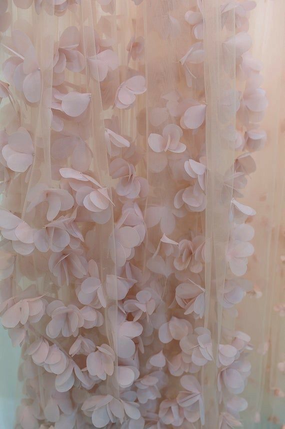 pink flowers hanging from the side of a sheer curtain